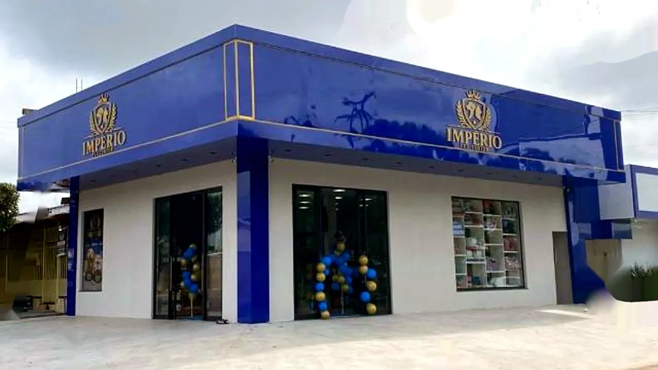 Fachada azul e dourada da loja Império, com vitrines e balões na entrada